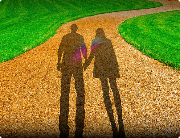 Shadows of a couple walking together holding hands on a path